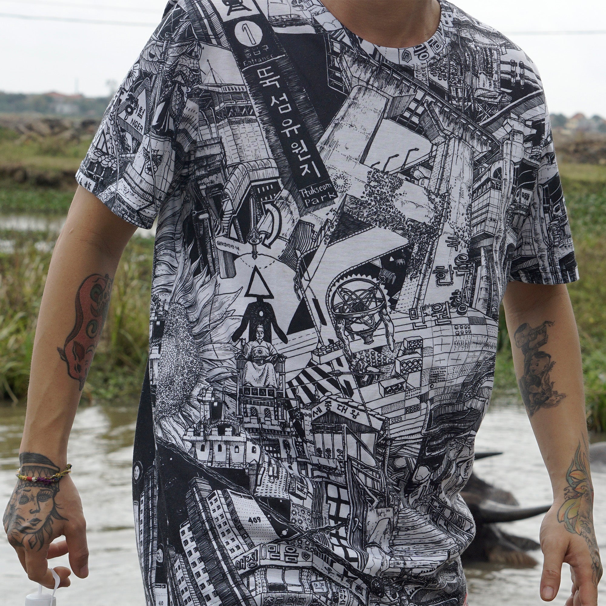 tattooed person wearing black and white all over printed city tshirt by heiner radau