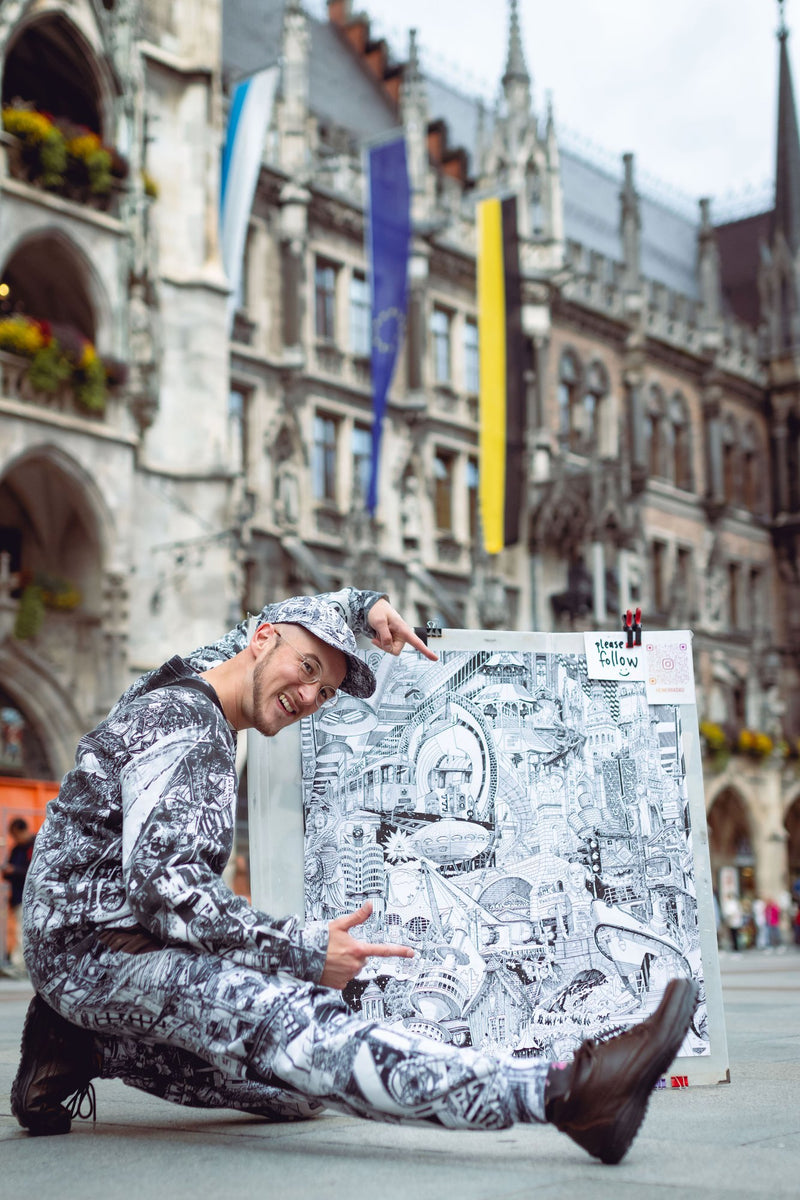 Kneeling with the finished sheet, Munich – Heiner Radau, Travel & Draw Munich