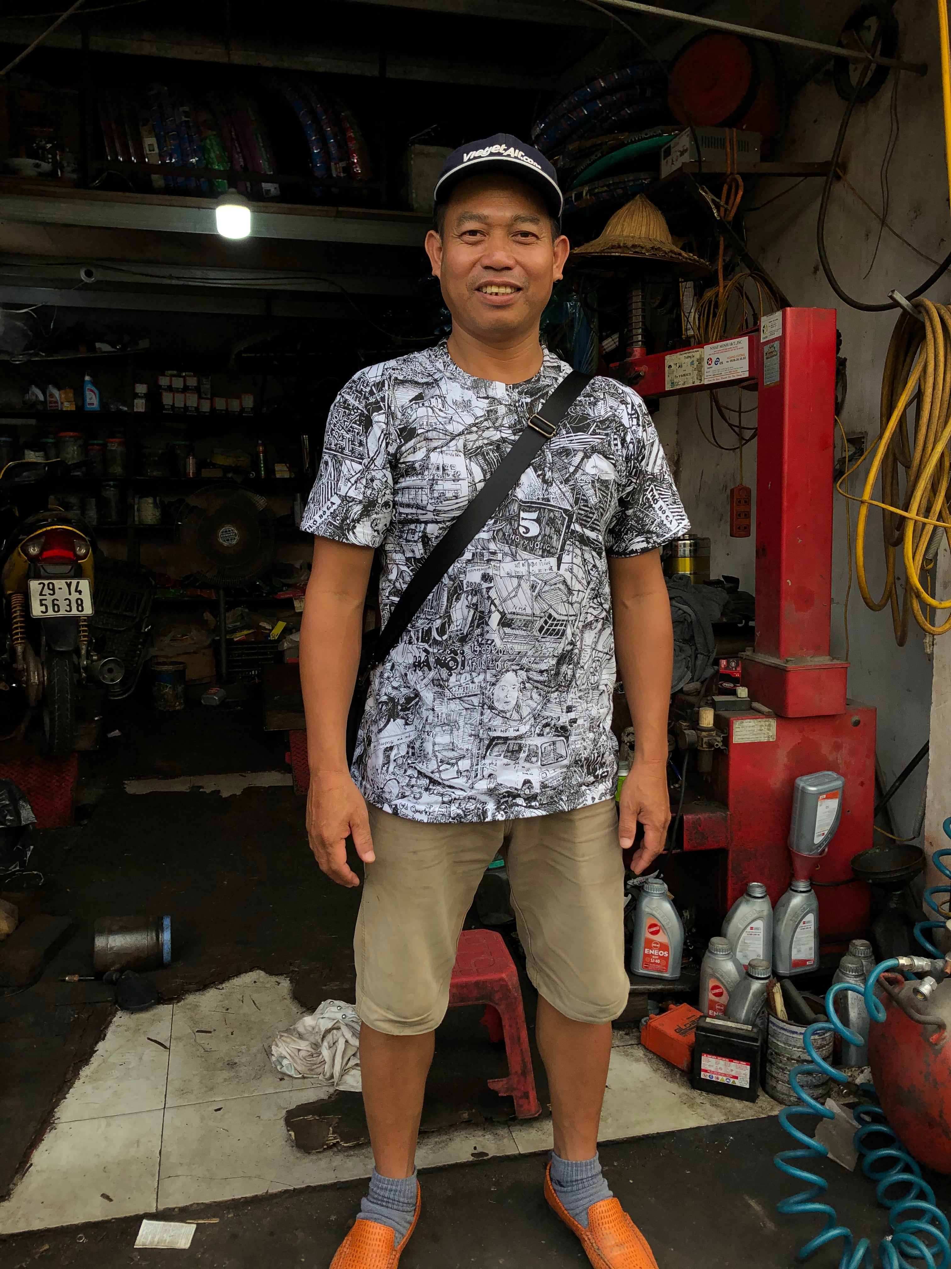 vietnamese motorbike mechanic man wearing black and white all over printed HANOI city tshirt by heiner radau