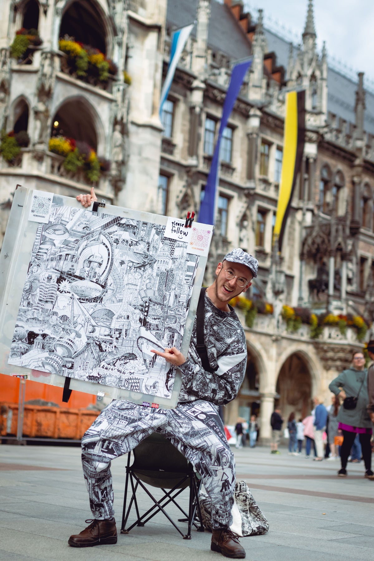 Heiner Radau praesentiert sein handgezeichnetes Muenchen-Kunstwerk auf dem Marienplatz — Travel and Draw, live gezeichnet vor Ort in der Muenchener Altstadt.