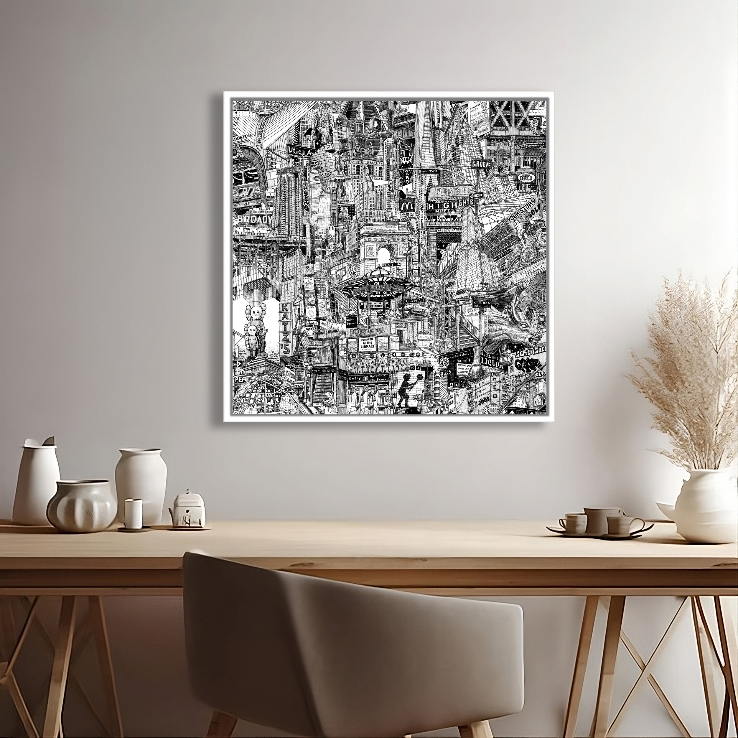 Framed black and white graphic urban artwork on a wall above a wooden desk with decorative items.