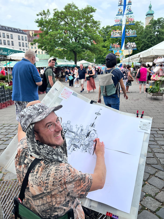 Heiner Radau zeichnet den Maibaum auf dem Viktualienmarkt — das Muenchen-Kunstwerk entsteht live im Herzen der Stadt.