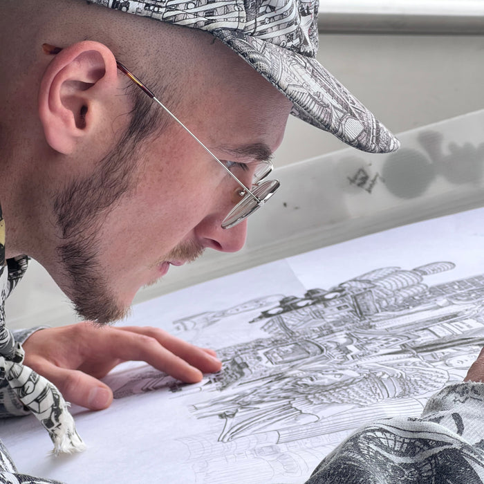 Heiner Radau portraitiert beim Zeichnen des Muenchen-Stadtkunstwerks — Travel and Draw live vor Ort mit Tinte und Feder.