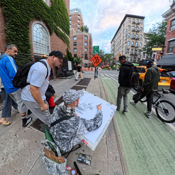 Heiner Radau sketching on a Greenwich Village sidewalk, creating hand-drawn New York City art from real street life.
