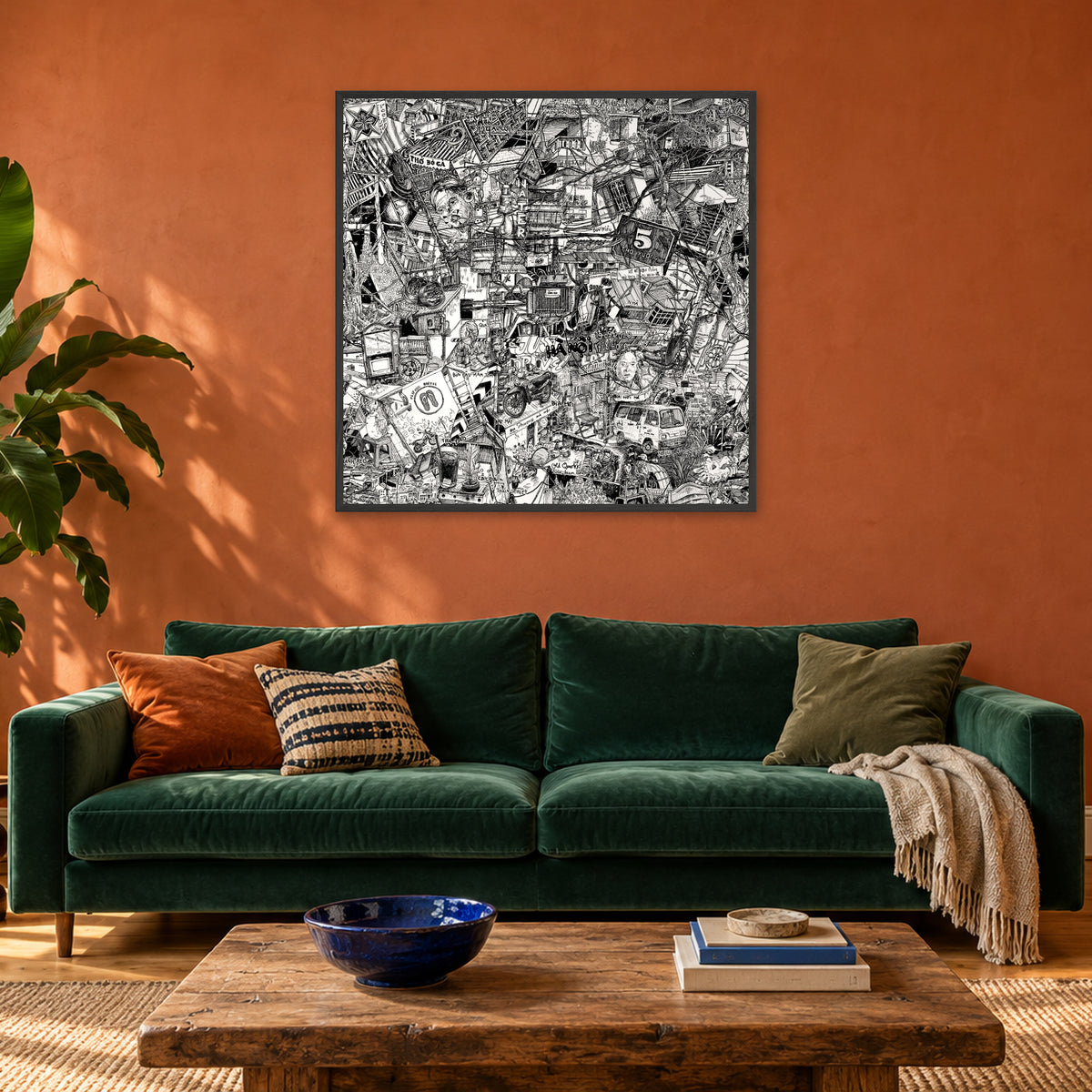 Hanoi fine art poster 100 × 100 cm in a black wood frame above a green velvet sofa in a terracotta living room