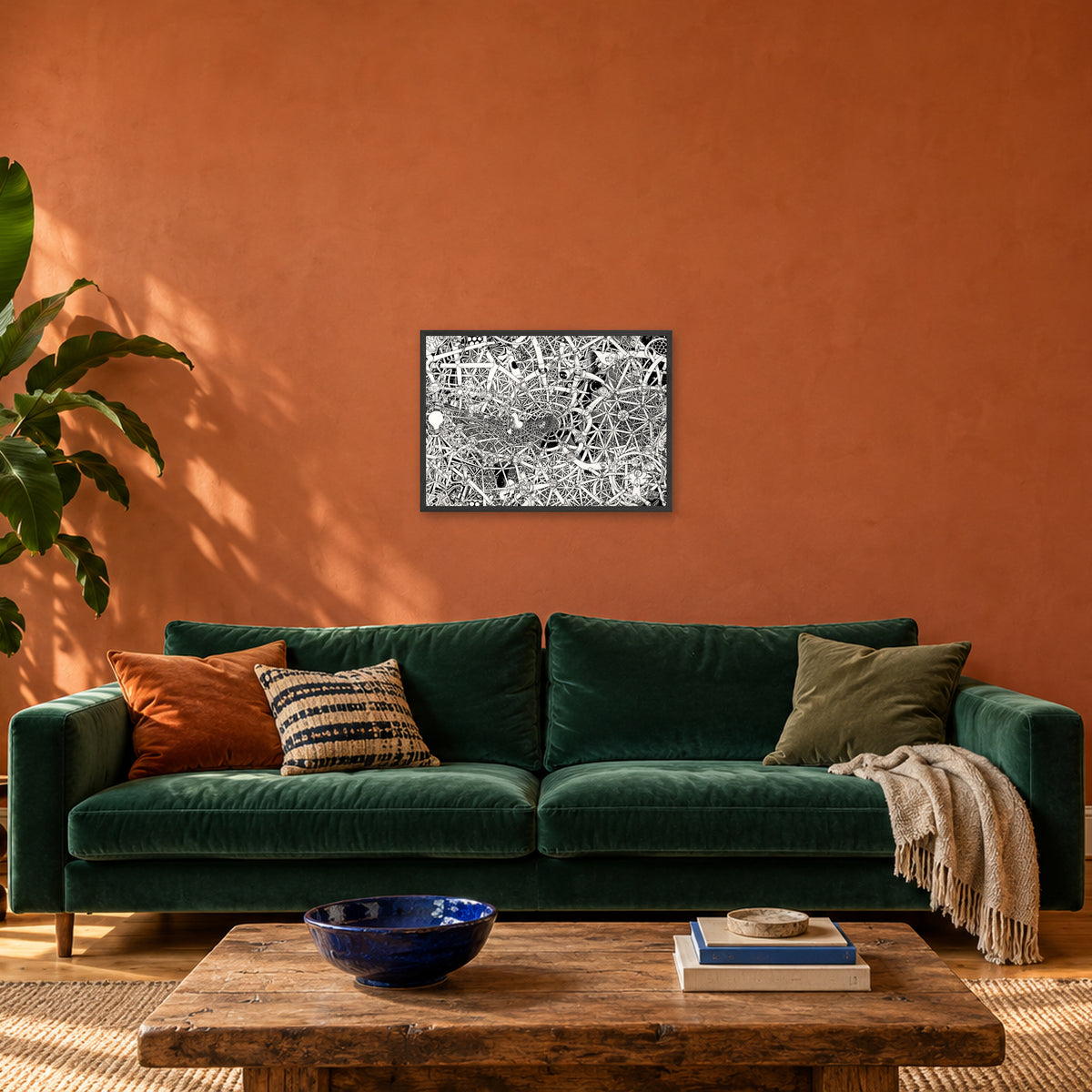 Universe fine art poster A2 landscape in a black wood frame above a green velvet sofa in a terracotta living room